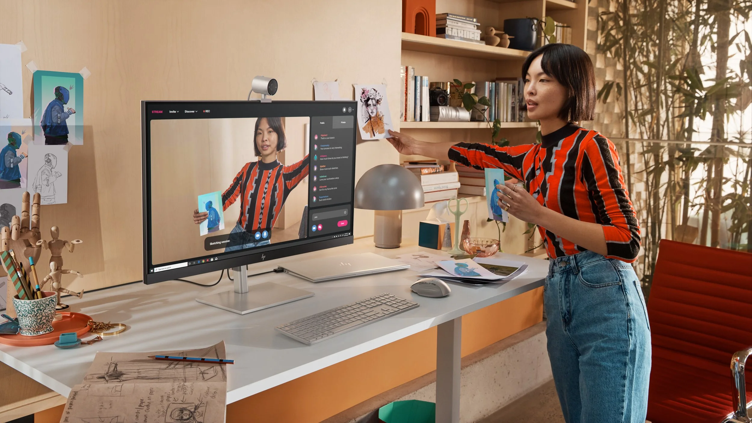 Woman presenting clothing to a desktop camera and monitor