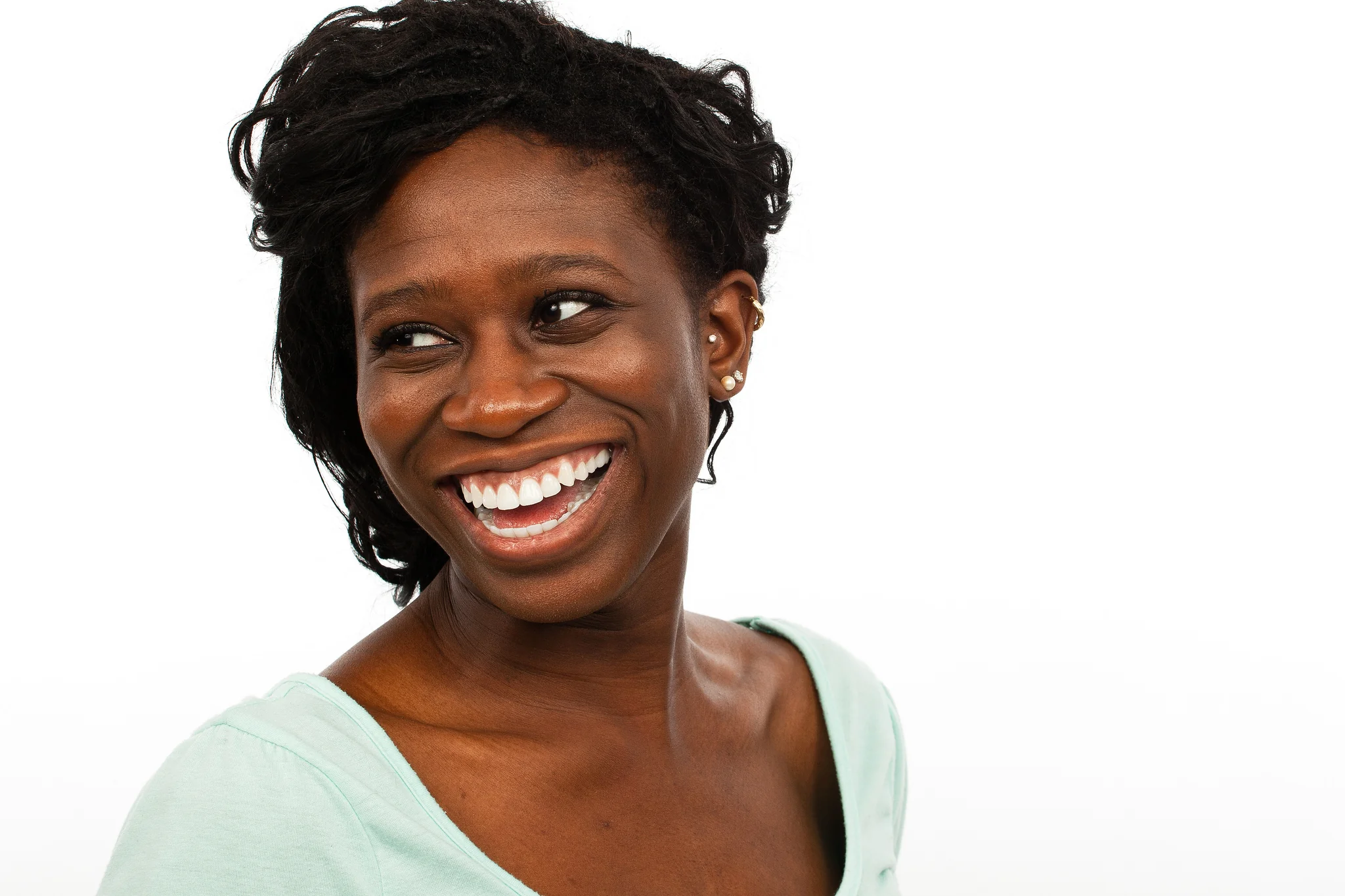 Smiling woman in a pale green top against white