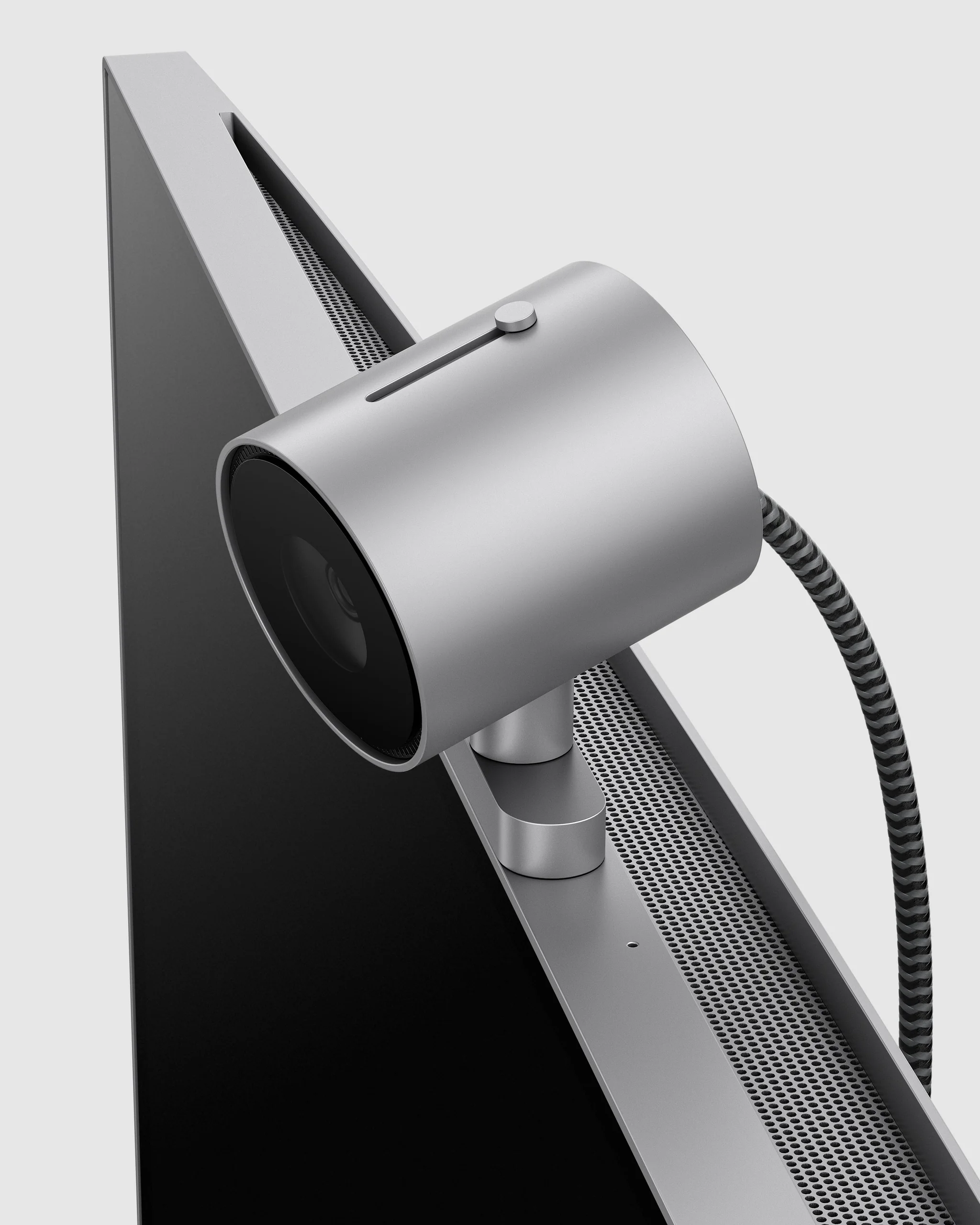 Cylindrical webcam clipped to the back of a silver monitor