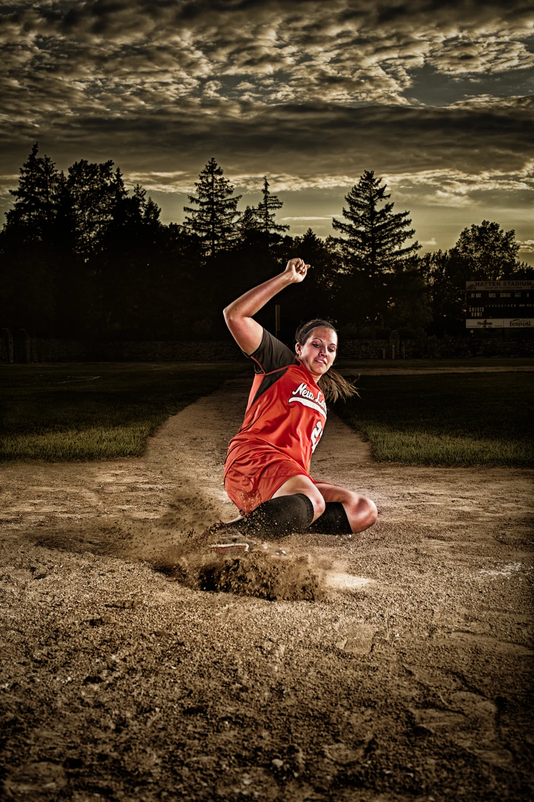 Baseball pitcher throwing from a dirt field at dusk